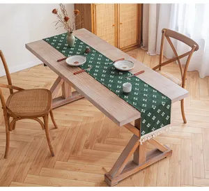 Camino de mesa de algodón verde con estrellas caladas y borlas en un comedor acogedor
