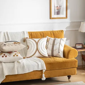 Bohemian style tufted cotton cushion covers with tassels displayed on a yellow velvet sofa