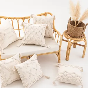 Housse de coussin bohème crème tissée avec glands pour décoration de canapé élégante.