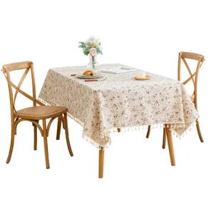 French rural floral tablecloth with elegant tassel edges displayed on a wooden dining table