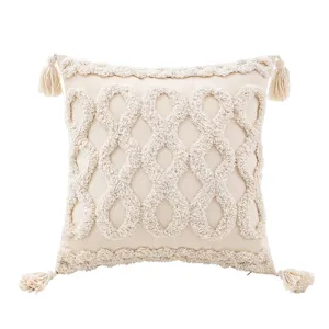 Housse de coussin boho avec glands et texture tissée géométrique pour déco de canapé.
