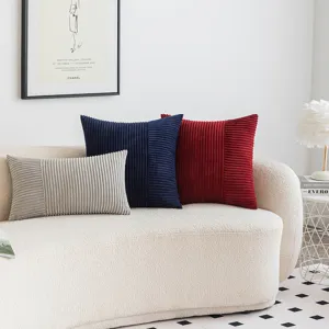 Moderne Cord-Patchwork-Kissenbezüge auf einem weißen Sofa in einem minimalistischen Wohnzimmer