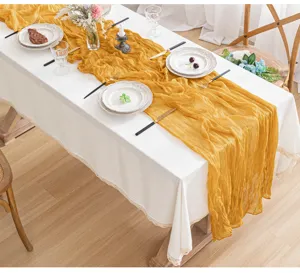 Runner in garza giallo senape su tovaglia di pizzo bianca per decorazione della tavola