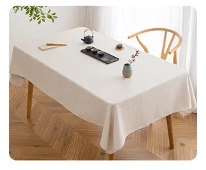 Detail of a minimalist beige rectangular tablecloth with a linen-like woven texture.