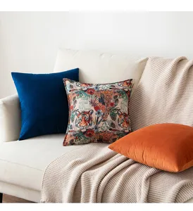 Lifestyle shot of vintage tiger jacquard and solid velvet cushions on a modern sofa.