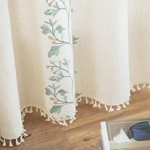 Close-up detail of modern embroidered curtains with floral patterns and tassel trim