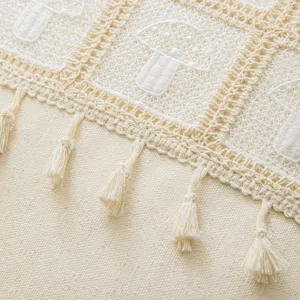 Detailed cream crochet cushion cover featuring mushroom patterns and elegant tassels