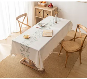Cream-style rectangular tablecloth with green leaf embroidery and tassels detail