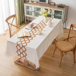Mantel nórdico bordado de algodón y lino con borlas geométricas en mesa de comedor