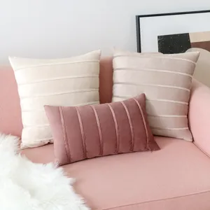 Modern velvet throw pillow covers with decorative stripes on a cozy pink sofa