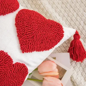 Housse de coussin brodée avec cœurs tuftés rouges et glands en toile texturée de qualité