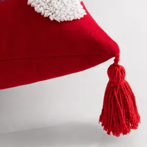 Housse de coussin rouge élégante avec broderie blanche et détail festif de pompon rouge