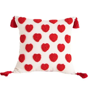 Housse de coussin décorative blanche avec cœurs tuftés rouges et pompons pour la maison