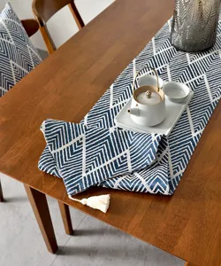 Détail du chemin de table jacquard japonais avec motifs de vagues et gland en coton blanc.
