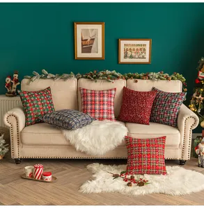 Gemütliche Weihnachtsszene mit verschiedenen karierten Deko-Kissen auf einem Sofa