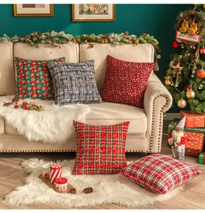 Festliche Weihnachtskissen mit Schneeflocken und Karomuster in gemütlicher Wohnzimmer-Deko.