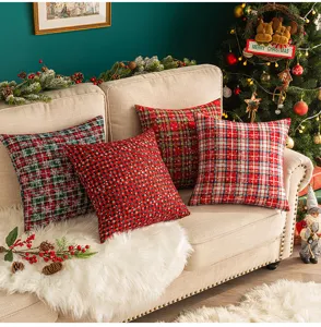 Verschiedene Weihnachts-Karo- und Schneeflocken-Kissen auf einem Sofa