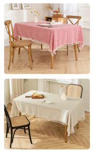 Detailed view of red and beige gingham tablecloths with white tassel fringes