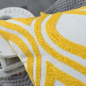 Dettaglio della federa per cuscino in stile nordico con ricamo geometrico giallo 3D