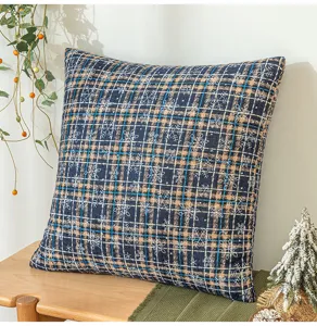 Detail eines blauen Weihnachts-Kissen mit Schneeflocken auf einer Holzbank