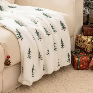 Zachte kerstdeken van imitatiekonijnenbont met prachtig geborduurde kerstbomen.