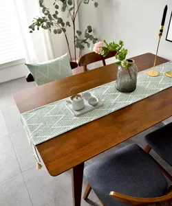 Élégant chemin de table en jacquard japonais avec motifs géométriques verts et pompons