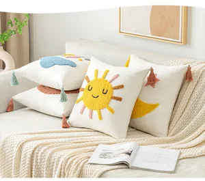 Fundas de cojín tejidas con motivos de sol y nubes en un acogedor sofá blanco de salón