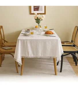 Elegant white lace tablecloth with floral embroidery shown in a warm, rustic dining setting