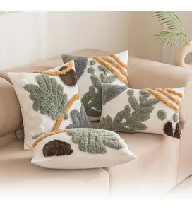 Bohemian getuftete Kissenbezüge mit grünen Blattmustern auf einem beigen Sofa