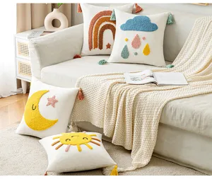 Escena de estilo de vida con cuatro fundas de cojín tejidas con motivos infantiles.