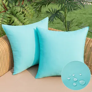 Turquoise outdoor waterproof pillow covers on wicker chair with water-resistant detail