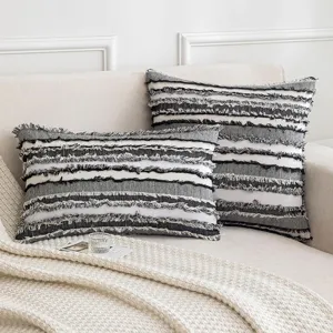 Fundas de cojín modernas a rayas con flecos en un acogedor sofá de color crema