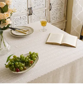 Detailed macro view of white embroidered lace tablecloth in a pastoral dining setting