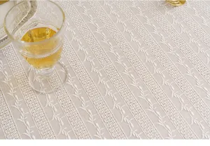 Close-up detail of white lace tablecloth with elegant leaf pattern embroidery