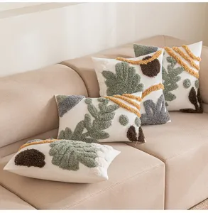 Detailansicht von vier böhmischen getufteten Dekokissen auf einem beigen Sofa