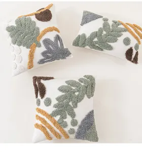 Detaillierte Ansicht von drei Boho-Kissenbezügen mit grünen und gelben geometrischen Mustern