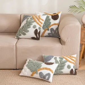 Boho-Kissenbezüge mit getufteten Mustern auf einem beigefarbenen Sofa
