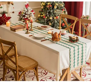 Woven cotton linen table runner with tassels displayed on a festive Christmas dining table