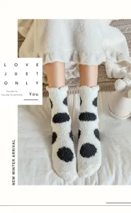 Detalle de calcetines blancos suaves con lunares negros para el invierno en casa.