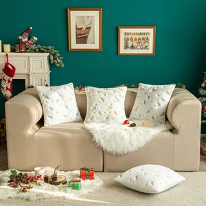 Plush white Christmas tree embroidered cushion covers set on a cozy sofa.