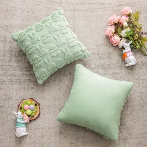Pair of green plush Easter cushion covers with bunny and egg textured patterns.