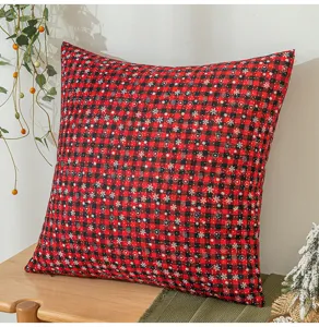 Detailansicht eines rot-schwarz karierten Weihnachtskissens mit Schneeflocken