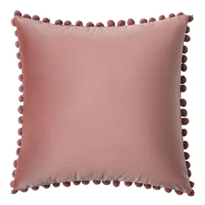 Funda de cojín de terciopelo rosa palo con bordes decorativos de pompones suaves
