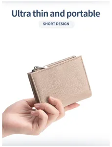 Detailansicht einer kleinen hellbraunen Geldbörse aus echtem Leder in der Hand.