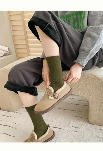 Detailed view of olive green wool socks paired with warm shearling-lined winter loafers