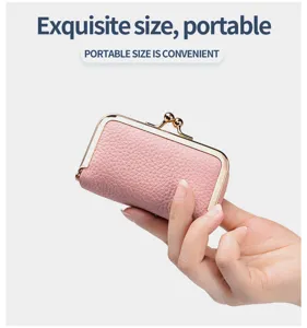 Close-up detail of a mini pink pebbled leather coin purse held in hand for scale