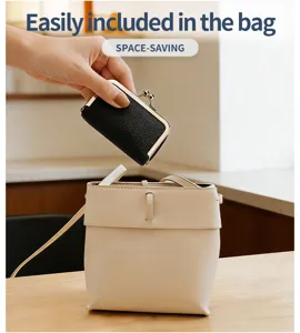 Mini genuine leather jewelry pouch being placed into a shoulder bag, space-saving size.