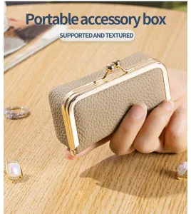 Detailed view of a portable genuine leather accessory box with an elegant gold clasp