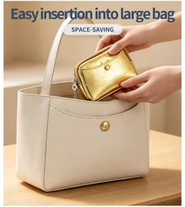 Vue détaillée d'un petit porte-monnaie doré à texture craquelée inséré dans un grand sac