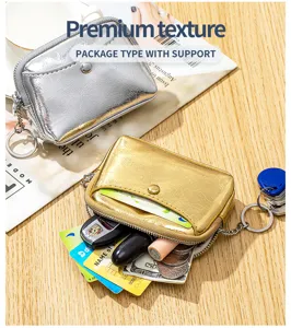 Détail d'un porte-monnaie à texture métallique craquelée avec cartes et clés de voiture